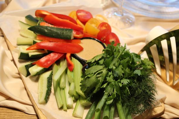 Тарелка свежих овощей с зеленью и ореховым соусом