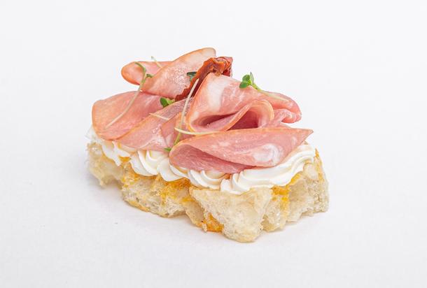 Брускетта с пармской ветчиной и вяленым томатом на подушке из сливочного мусса